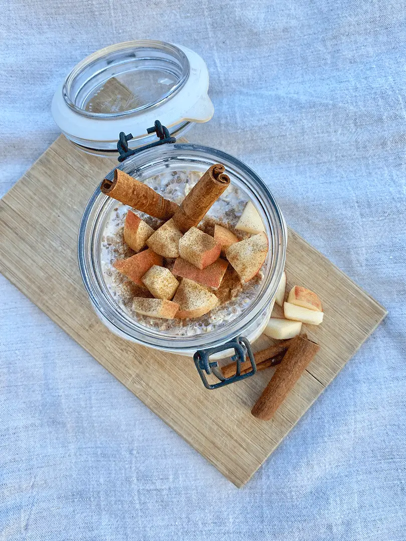 A bowl of cinnamon and diced apples on a wooden board
