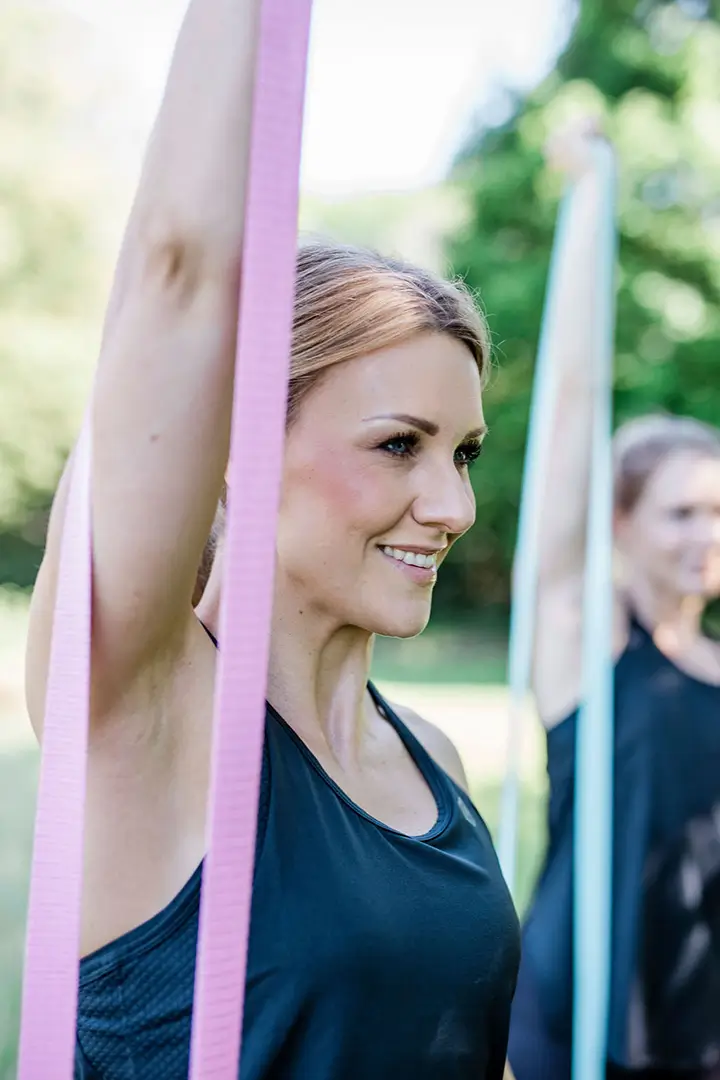 Female fitness trainer stretching a band
